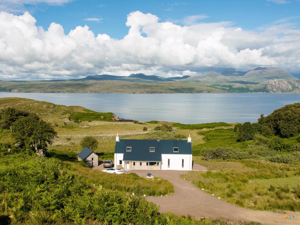 a house in a field next to a body of water at Tigh An Iasgair in Fearnmore