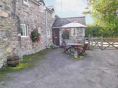 a table and chairs in front of a building at The Old Mill in Bampton