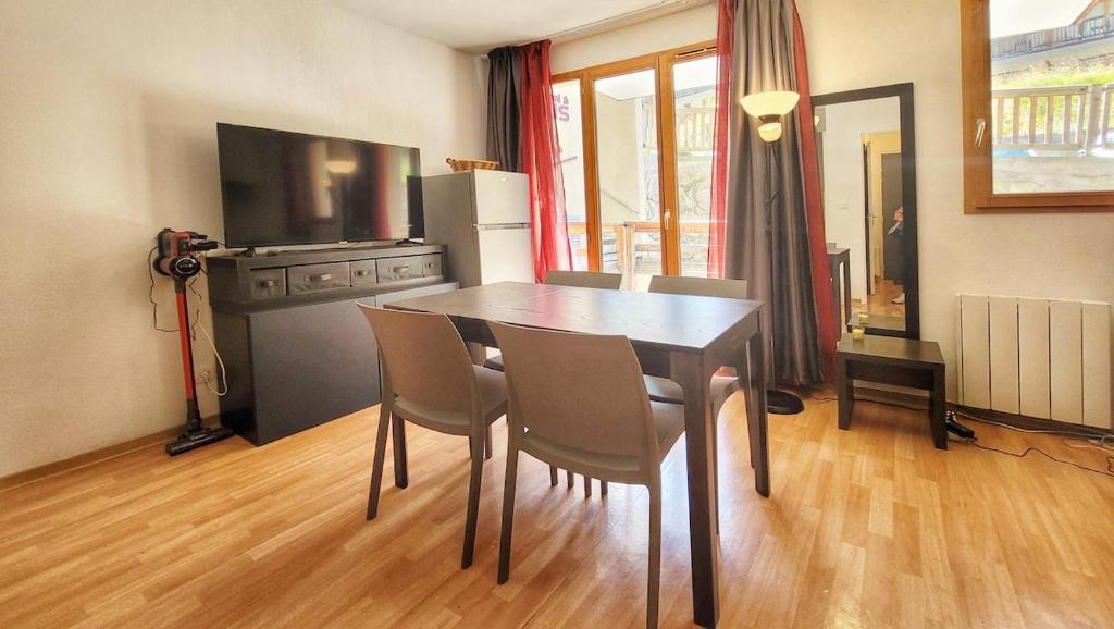 a kitchen with a dining room table and chairs at Studio tout équipé, piscine chauffée, départ skis aux pieds in Les Orres