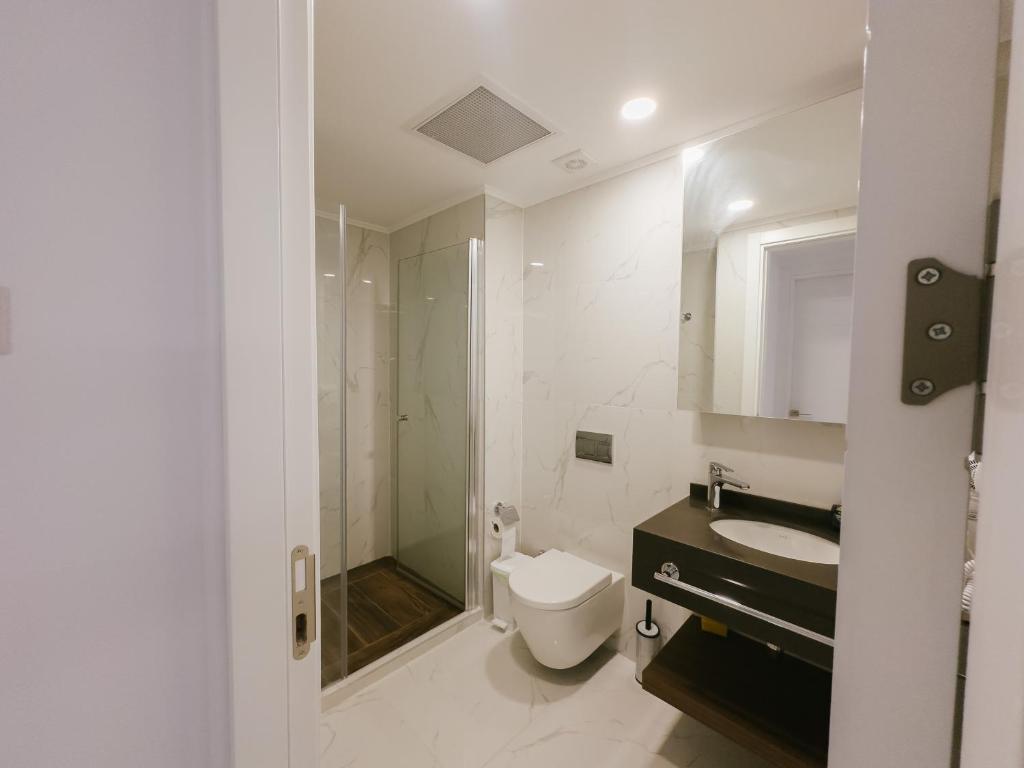 a bathroom with a toilet and a sink and a shower at Grand Sapphire Hotel, Casino & Spa Holiday Deluxe Residential Home in Iskele