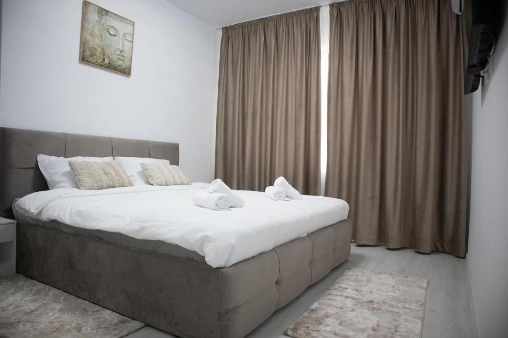 a bedroom with a large bed with two towels on it at Garsonieră Studio in Dudu