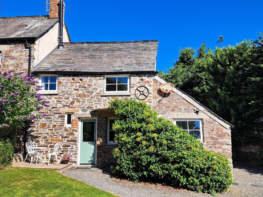 a stone house with a clock on the top of it at Appleloft in Crackington Haven