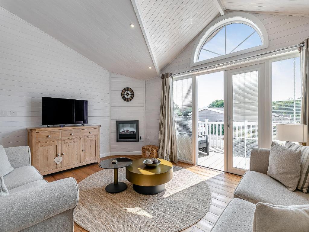 a living room with a couch and a tv at Fuchsia Lodge in Willington