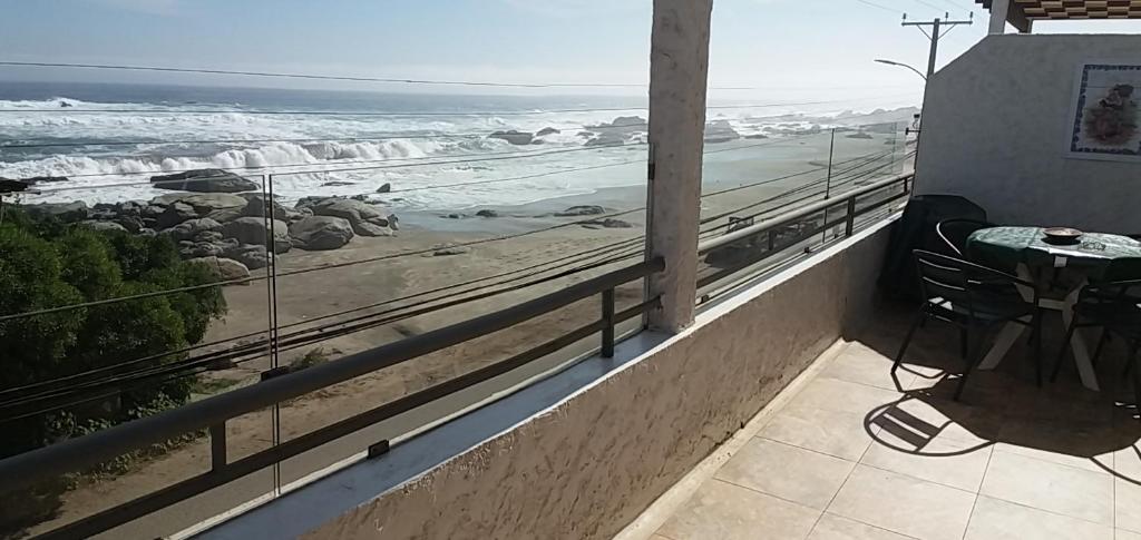 a balcony with a table and a view of the ocean at Maitencillo Opas Apartment in Maitencillo