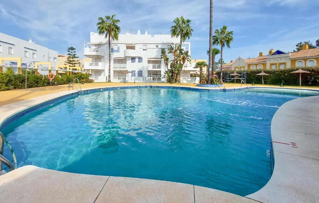 ein großer blauer Swimmingpool vor einem Gebäude in der Unterkunft 3 Bedroom Cozy Home In Islantilla - Isla Cris in Islantilla