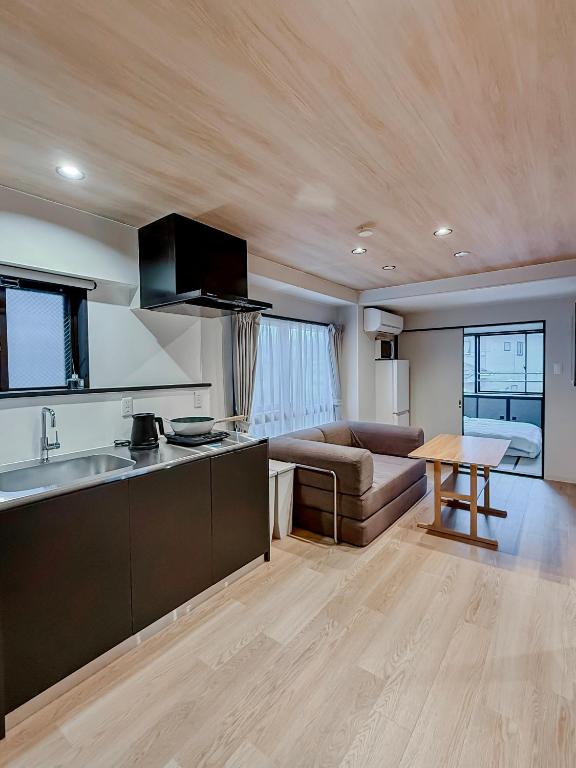 a kitchen and living room with a couch and a table at AURA YUZAWA Apartment Hotel - 1Bedroom Apartment with Living Dining Kitchen Sleeps 2 to 4, Bedroom with 2-Double Bed, Living Room with 1-Sofa Bed in Yuzawa