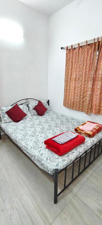 uma cama com almofadas vermelhas num quarto em The Duplex House HSR em Bangalore