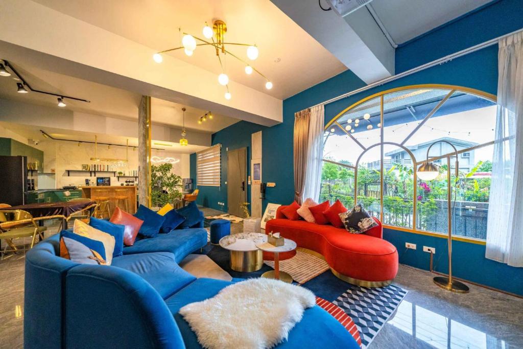 uma sala de estar com móveis azuis e vermelhos e uma grande janela em 浮雲拾光 em Dongshan