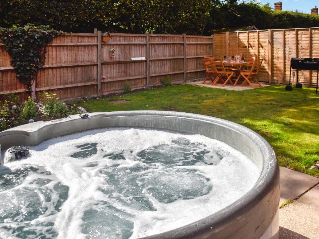 a jacuzzi tub in the backyard of a yard at Rowan Cottage in Northrepps