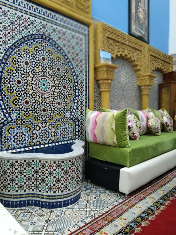 a room with a couch with pillows on a wall at Riad Sevilla in Rabat