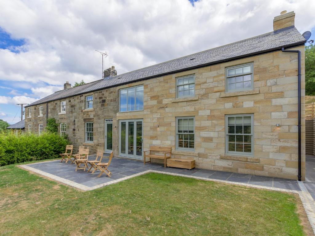 an exterior view of a stone house with a patio at Ivy Cottage in Beck Hole