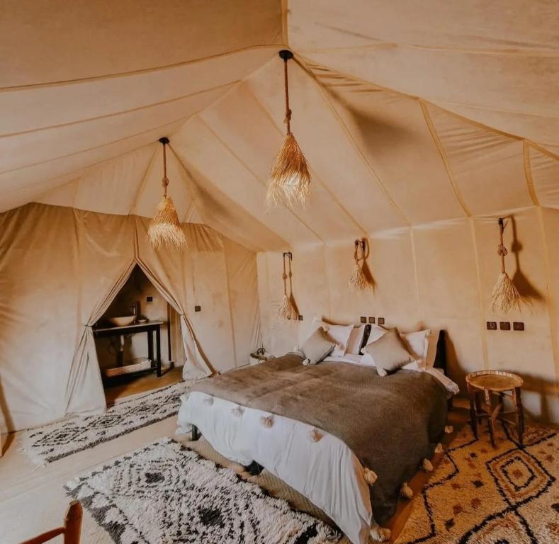 a bedroom with a bed in a tent at Merzouga Glossy Camp in Merzouga