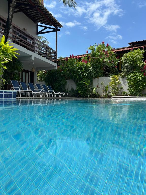 a swimming pool with chairs and a house at Pousada Waikiki Boutique in Pipa