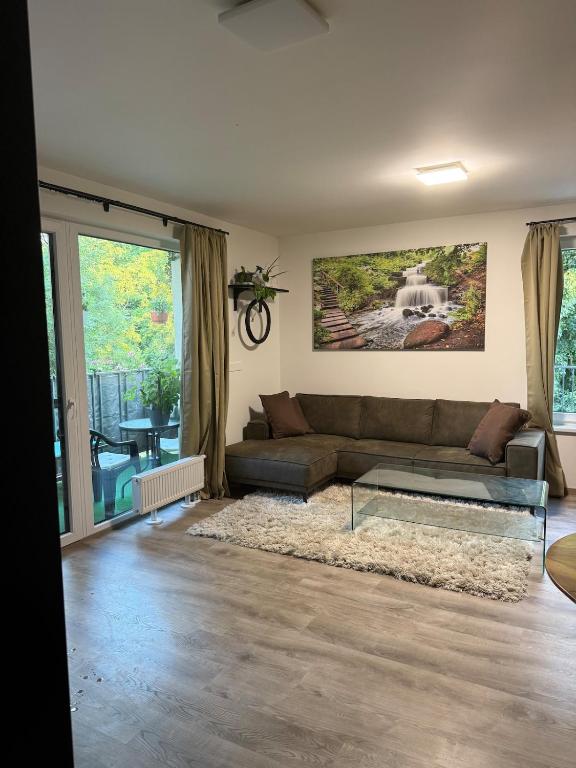 a living room with a couch and a glass coffee table at Modern Apartment in a Leafy Town Close to Prague 