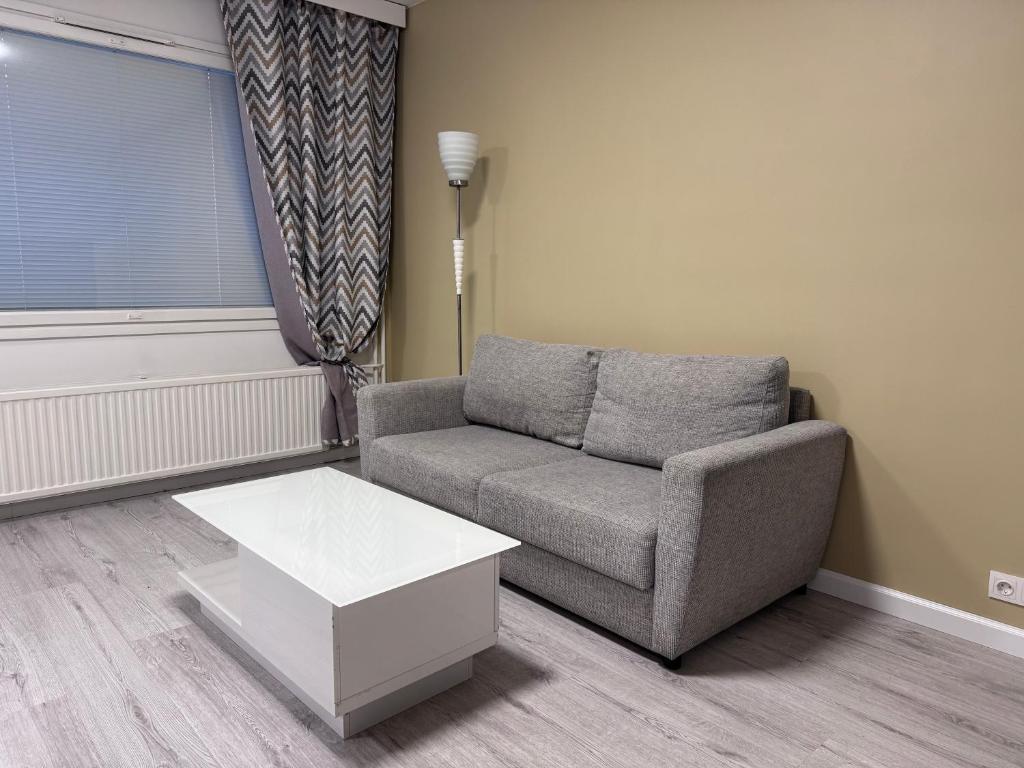 een woonkamer met een bank en een salontafel bij Warm apart in Kouvola