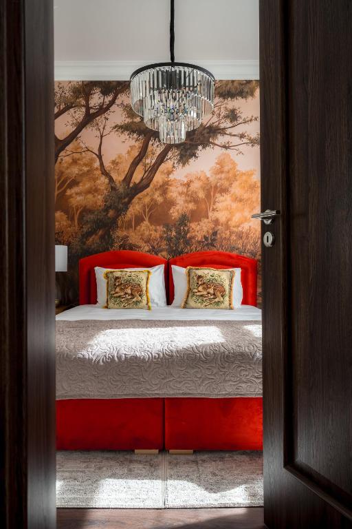 a bedroom with a bed with a painting on the wall at Piotrkowska 89 Residence in Łódź