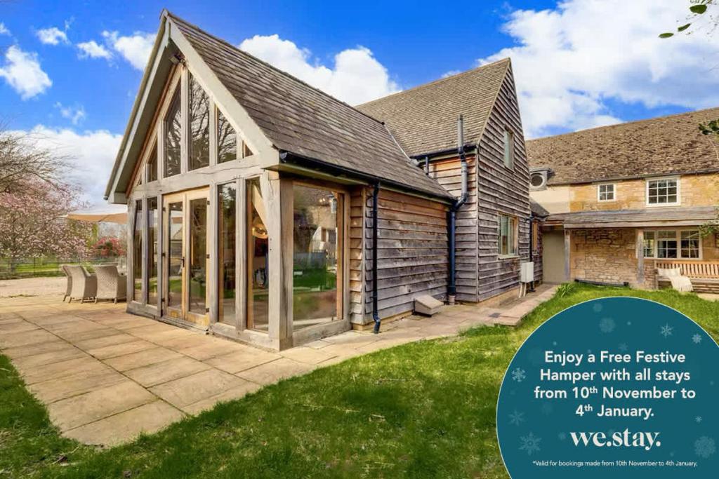 une maison avec une véranda et des fenêtres en verre dans l'établissement Hiron's Piece - Hot Tub Packages Available, à Weston Subedge