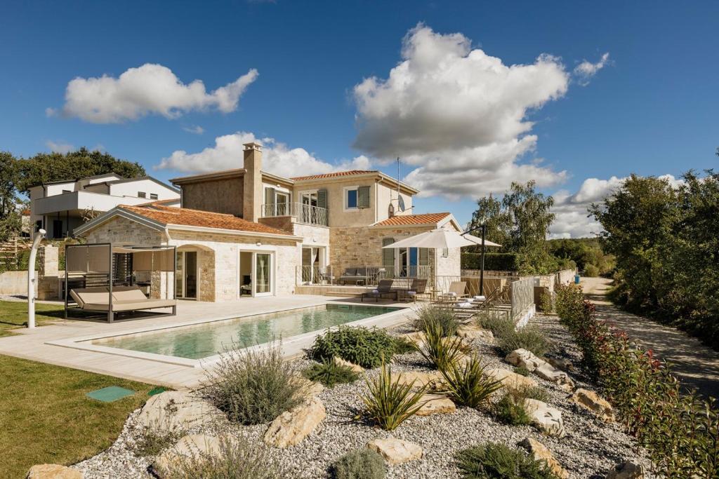 a home with a swimming pool and a house at Villa Mila with private pool, BBQ and jacuzzi in Strpačići