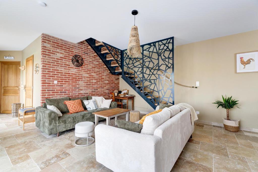 a living room with two couches and a staircase at L'atelier de Théo - Jacuzzi Privé in Chaourse-en-Thiérache