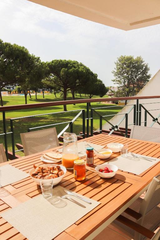 a wooden table with plates of food on it with a view at Luxury Apartment in Vila Sol Resort in Quarteira