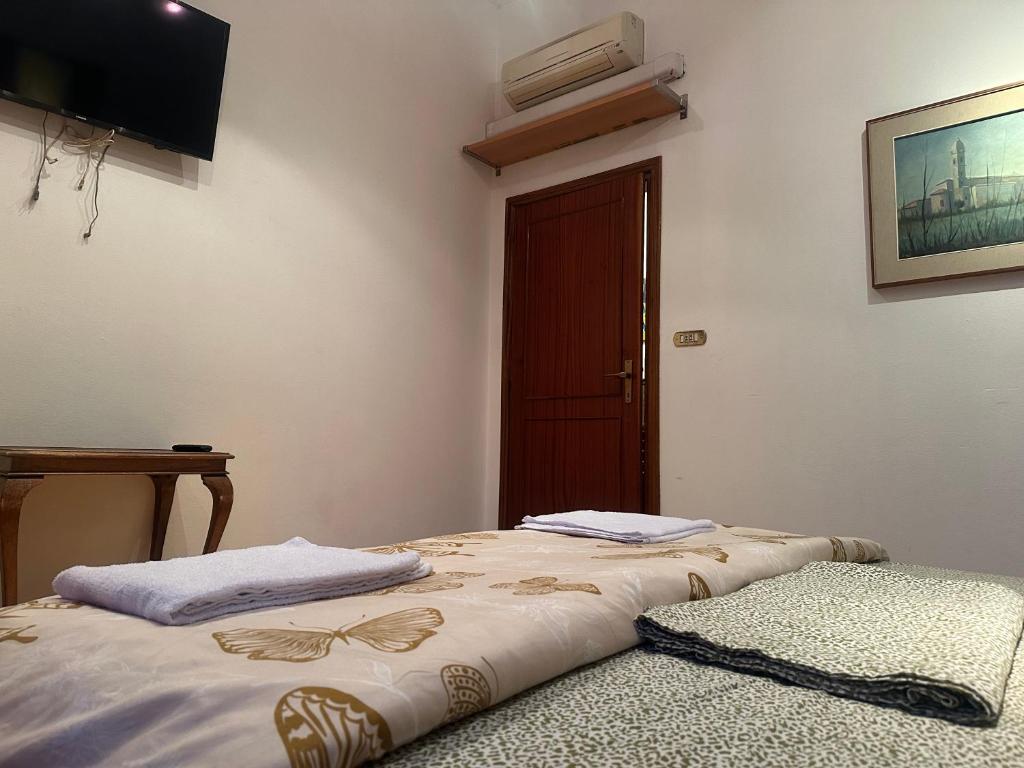 a bedroom with two beds with a television on the wall at Bnb fantasia in Bologna