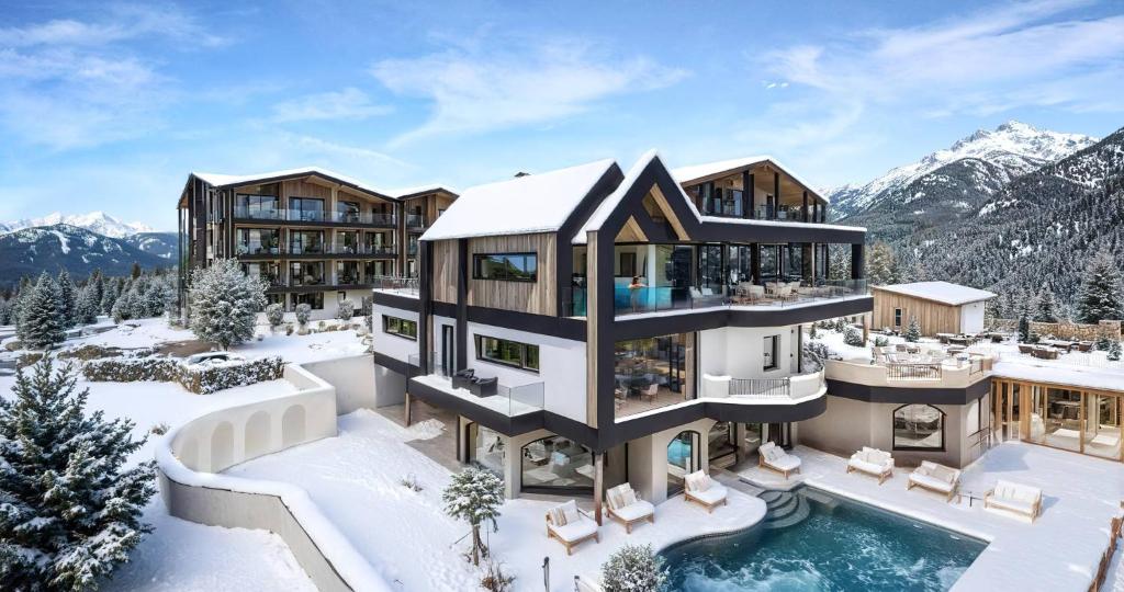 a house in the snow with a swimming pool at Forster's Naturresort in Neustift im Stubaital