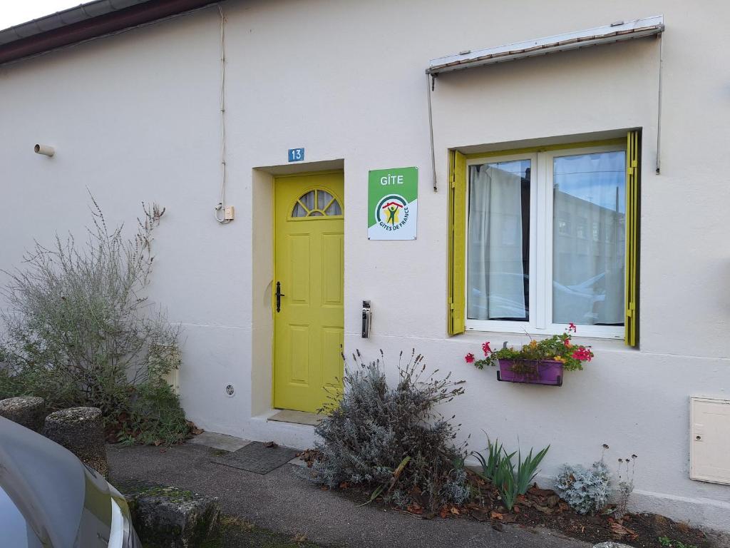 a yellow door on the side of a white building at Petite maison proche cathédrale centre 3 pers in Toul