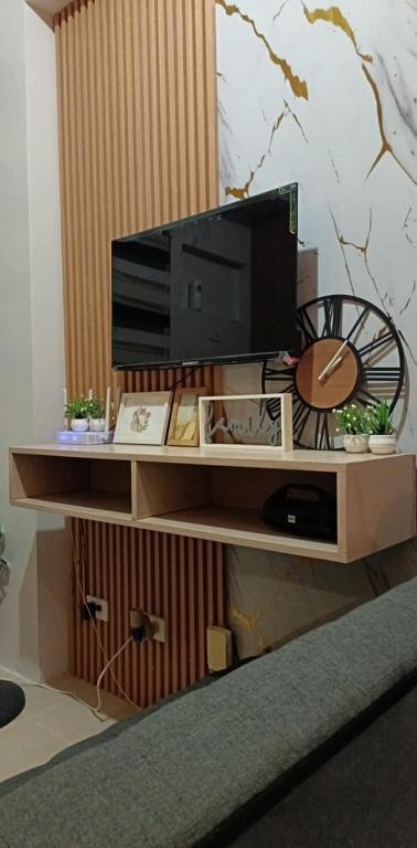 a flat screen tv on a wooden entertainment center at Cheers SMDC Condominium in Marilao