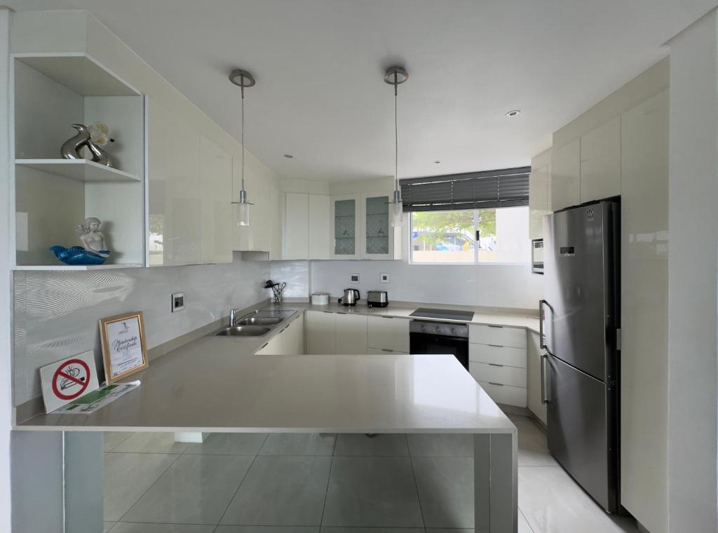 ダーバンにあるSea Lodge G01のシンクと冷蔵庫を備えた白いキッチン