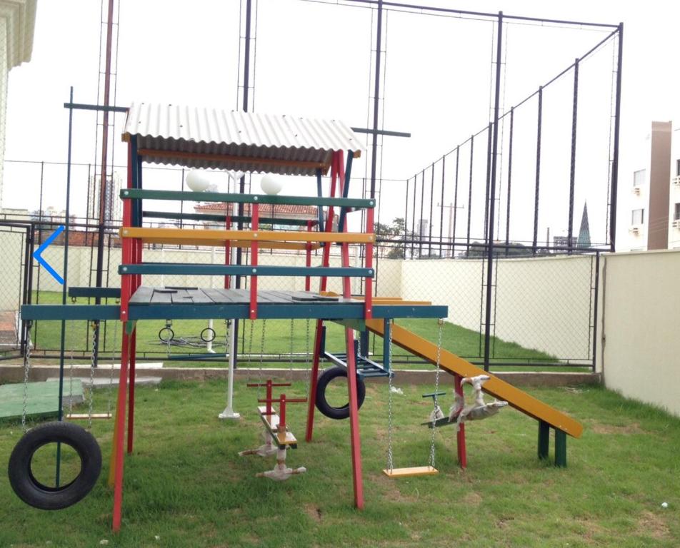 a playground with a seesaw and a slide at Gran Apartamento com Piscina - 3 Quartos in Cuiabá