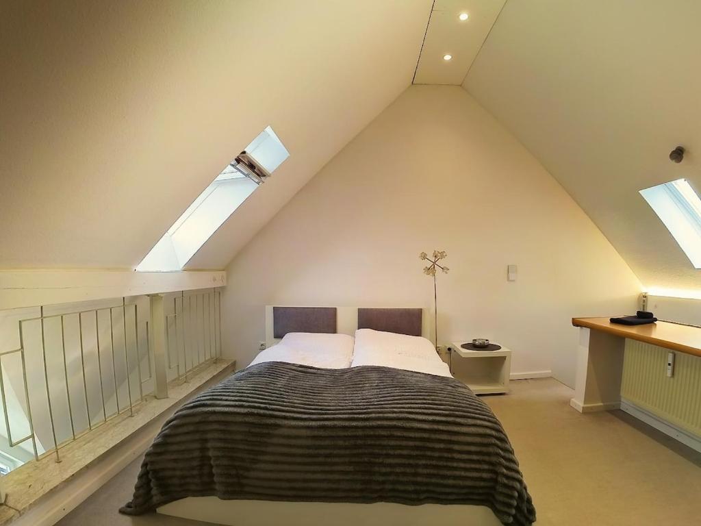 une chambre avec un grand lit dans un grenier dans l'établissement Ferienwohnung zwischen Nürnberg und Seenland, à Weißenburg in Bayern