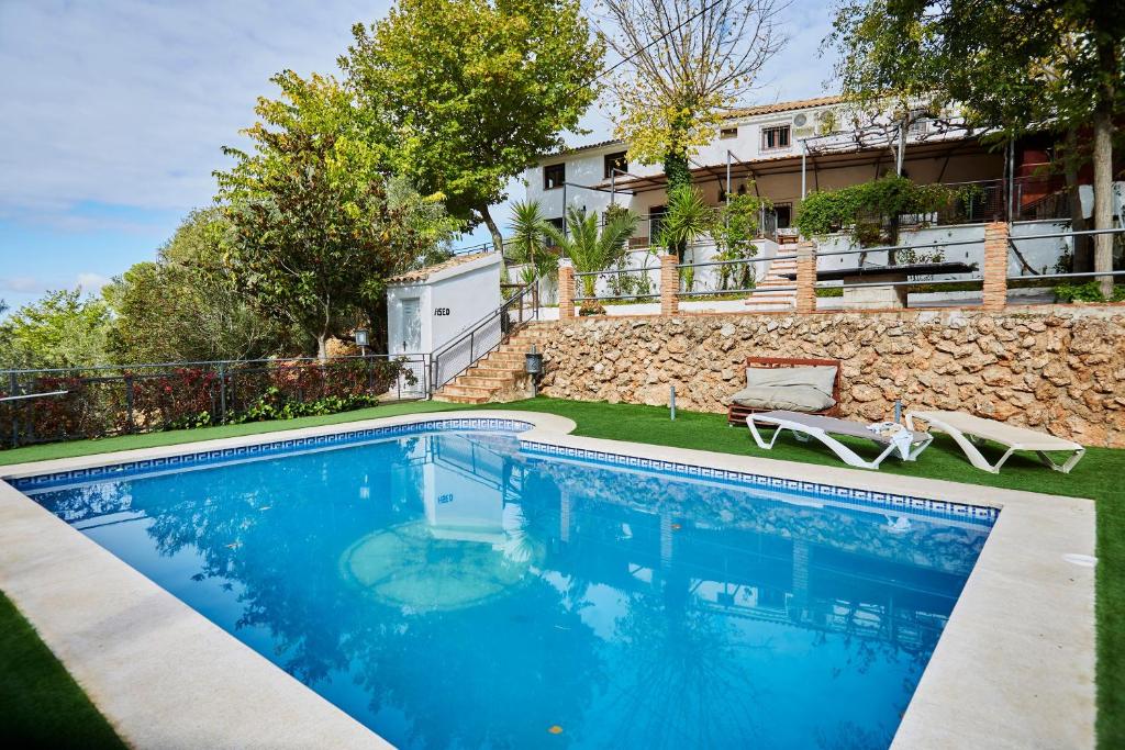 a swimming pool in a yard with a building in the background at Fuente Los Avellanos in Villanueva del Arzobispo