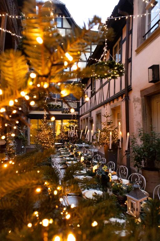 斯特拉斯堡Cour du Corbeau Hotel Strasbourg - MGallery Collection的庭院景色,灯光璀璨,桌椅错落有致。