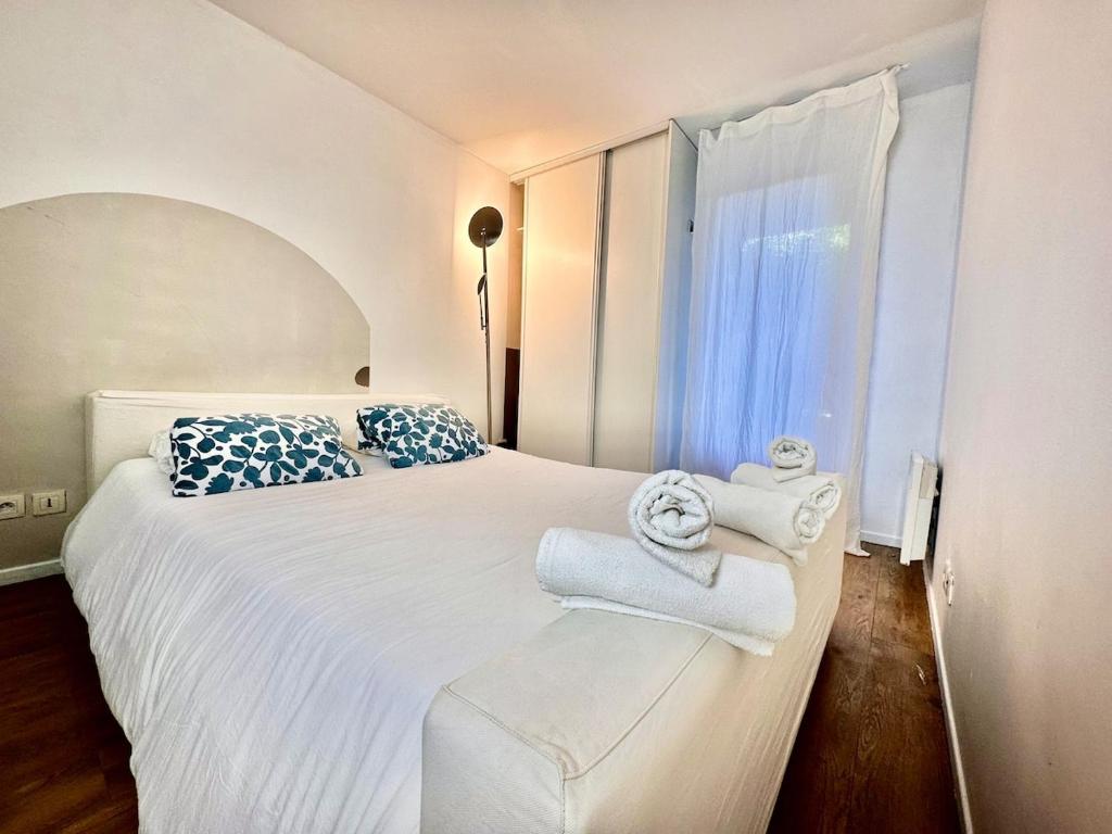 ein Schlafzimmer mit einem großen weißen Bett mit Handtüchern darauf in der Unterkunft KAALA STAYS - Family apt Disney - Paris Garden Parking in Noisy-le-Grand