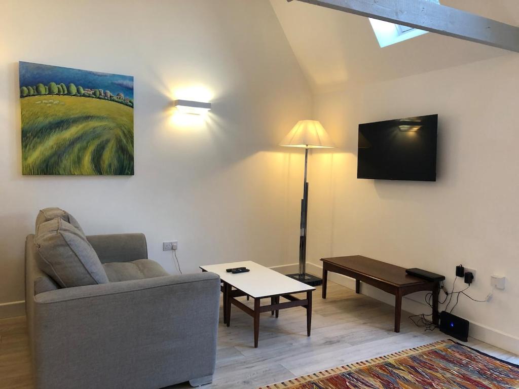 een woonkamer met een bank en een tv bij Perfitt Place in Bungay