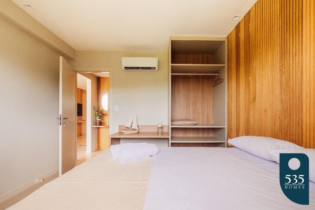 a bedroom with a large white bed and a desk at Praia do Forte 2 bedrooms Complete and Comfortable in Mata de Sao Joao