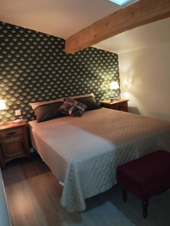 a bedroom with a large bed and two night stands at Au petit chai des Morinauds in Brives-sur-Charente