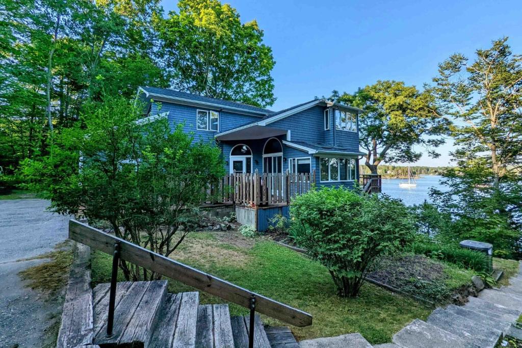 a blue house on the shore of a lake at High View in Dyer Cove