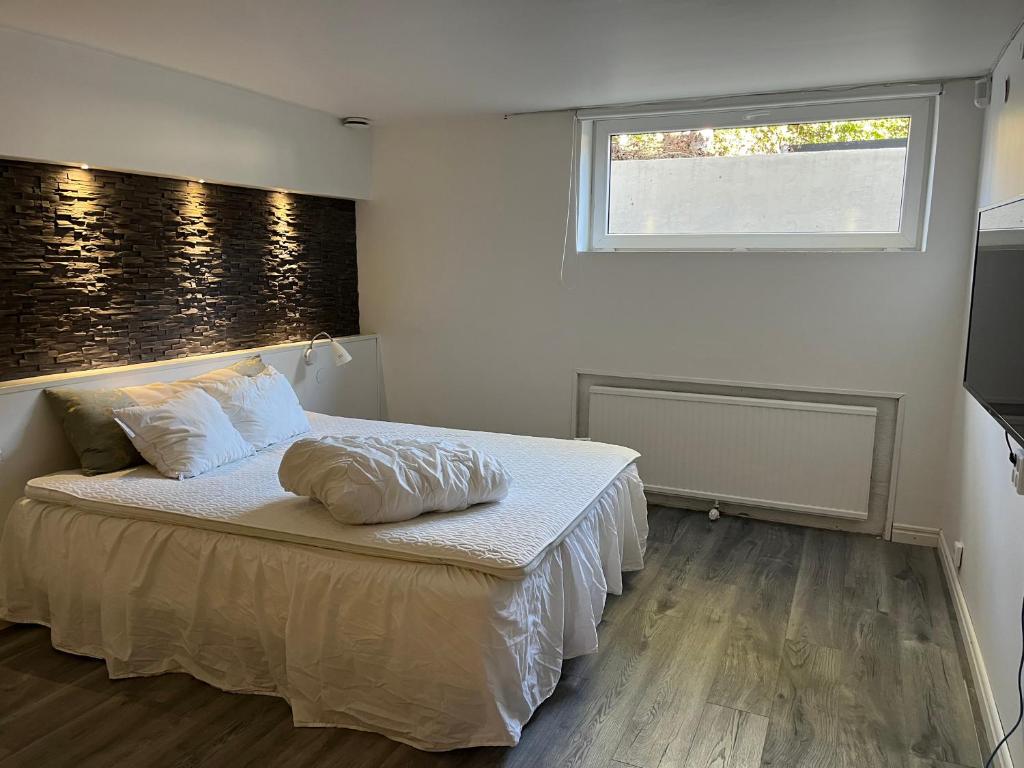 a bedroom with a bed with a pillow on it at Stenkällan - snabbuss 5 in Malmö