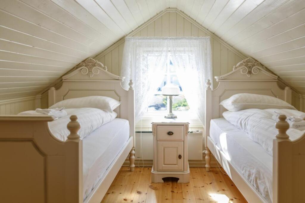 two beds in a attic bedroom with a window at STØTT top of Helgeland in Støtt