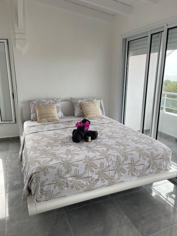 a teddy bear sitting on a bed in a bedroom at Villa Bel'Horizon in Capesterre