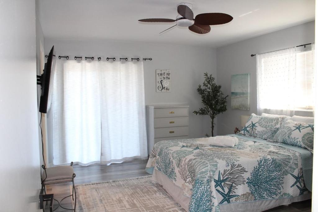 una camera da letto con un letto e un ventilatore a soffitto di Blue Paradise a Englewood