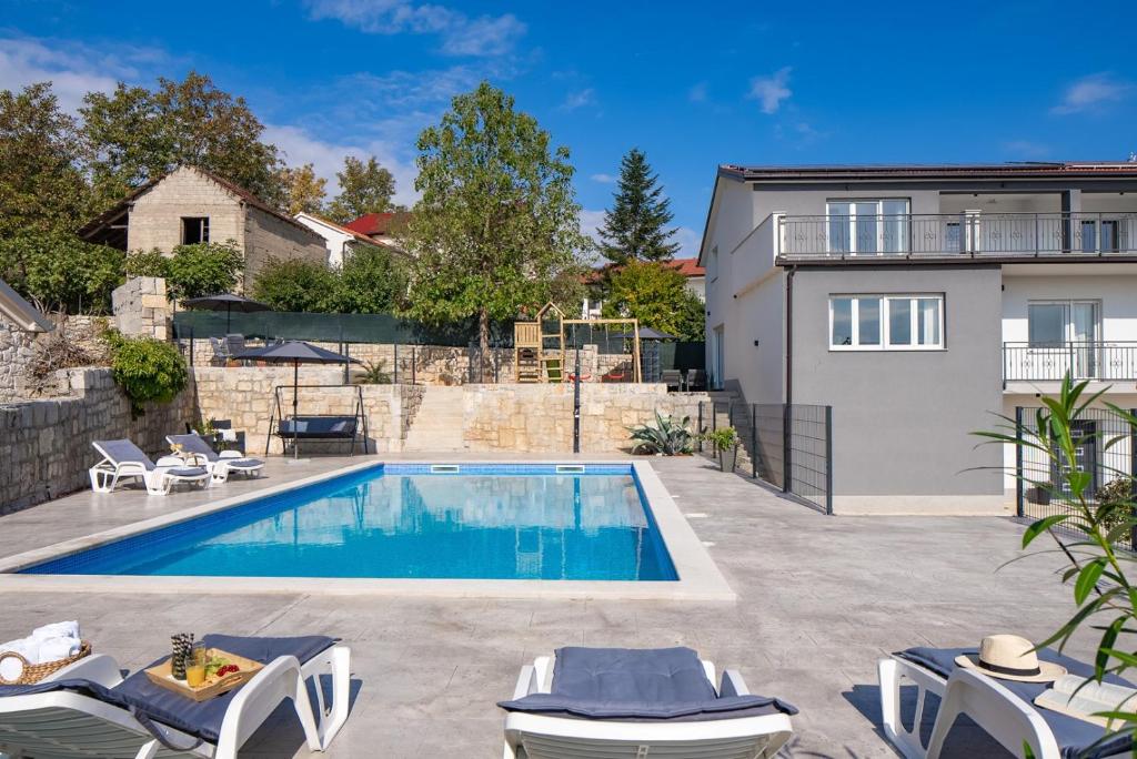 ein Swimmingpool im Hinterhof eines Hauses in der Unterkunft Villa Gloria: Stylish 5-Bedroom Retreat with Private Pool and Stunning Valley Views in Zmijavci