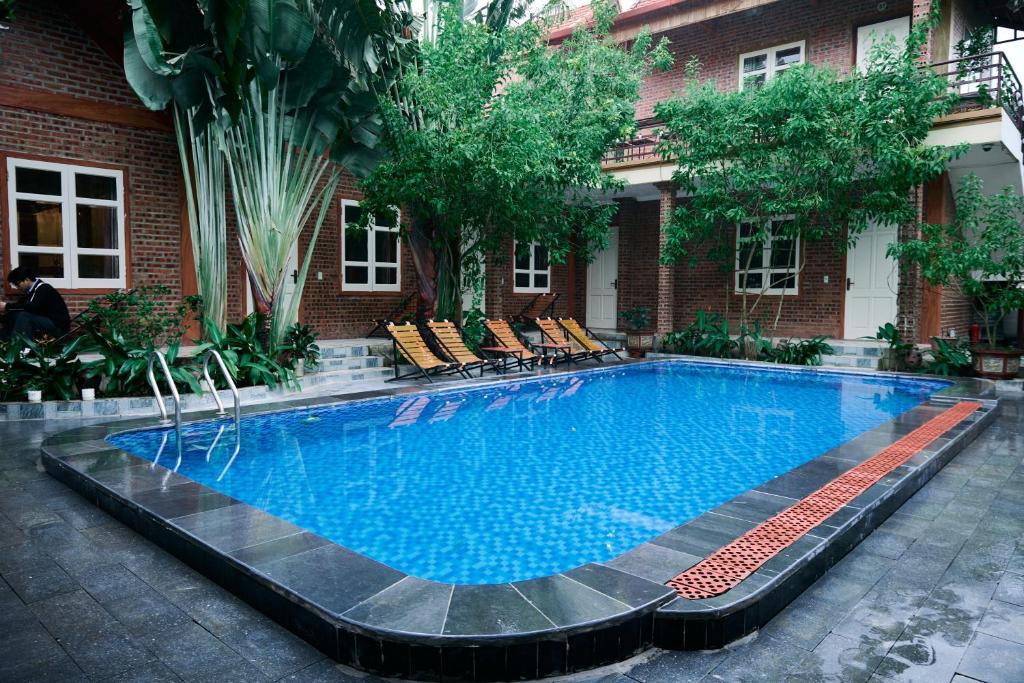 a large swimming pool in front of a building at Cosiana Homestay in Ninh Binh