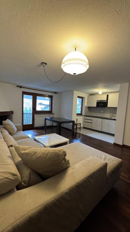 a large living room with two couches and a kitchen at L'Atelier du Temps - Voicing House in Courmayeur
