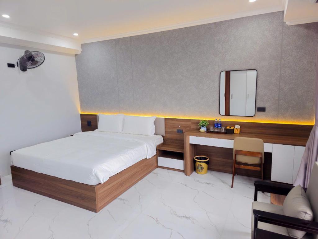 a bedroom with a bed and a desk and a mirror at 阮黄酒店 in Hòa Ðình