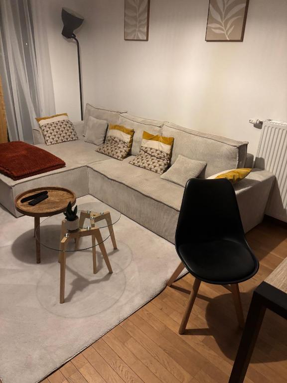 a living room with a couch and a table at Loft chaleureux avec wifi et terasse in Ceyrat