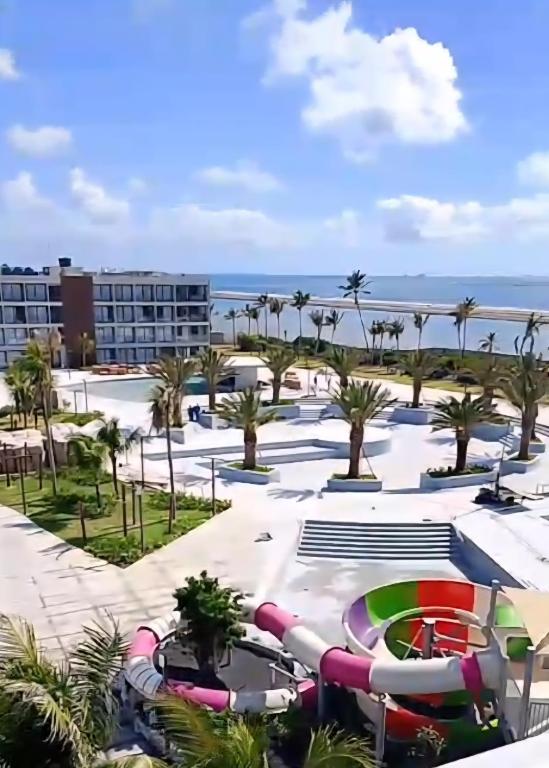 a resort with a pool and palm trees and the ocean at Porto 2 Life Resort in Porto De Galinhas