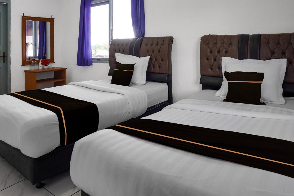 Un pat sau paturi într-o cameră la Collection O near Universitas Negeri Padang formerly Hotel Amra