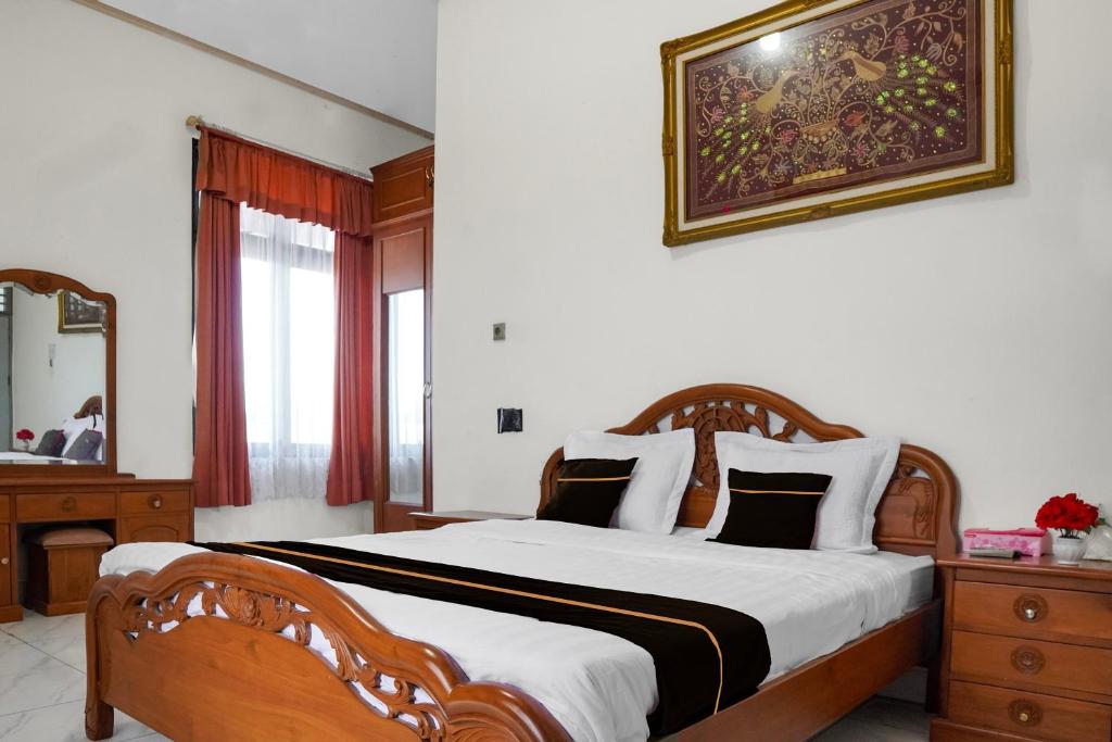 a bedroom with a large bed with a wooden frame at Collection O near Universitas Negeri Padang formerly Hotel Amra in Padang